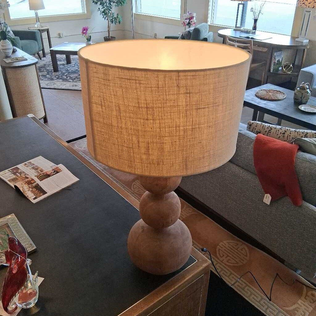Lamp with a woven shade on a table in a living room setting