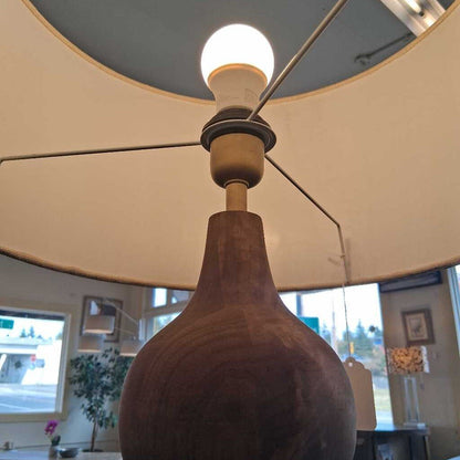 Close-up of a wooden pendant light fixture with a white lampshade.