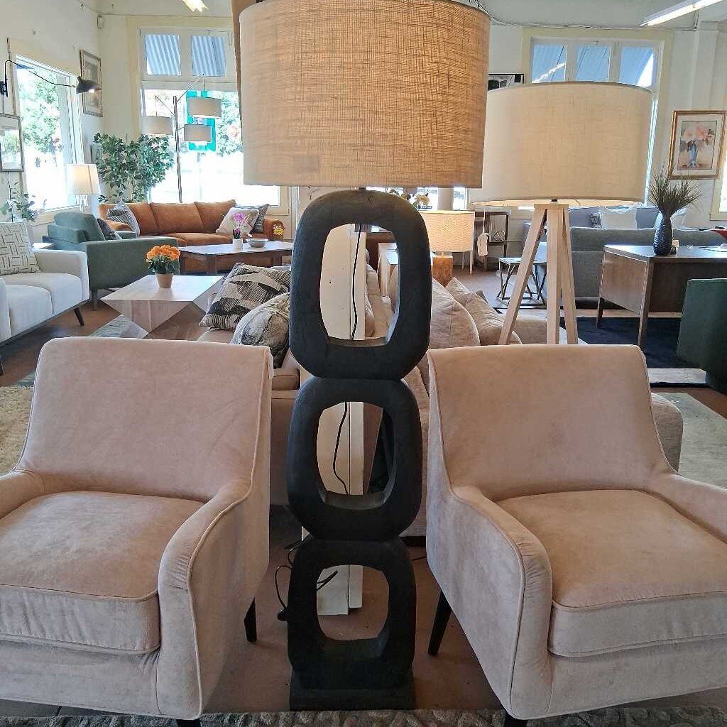 Living room with beige chairs, a black lamp, and a lampshade.