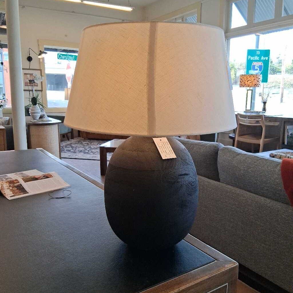 Table lamp with beige shade on a table in a room setting