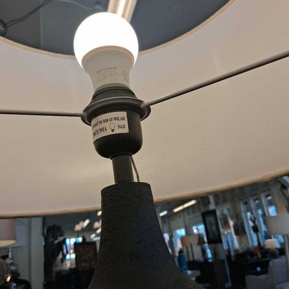 Light bulb inside a lampshade with a blurred indoor setting in the background