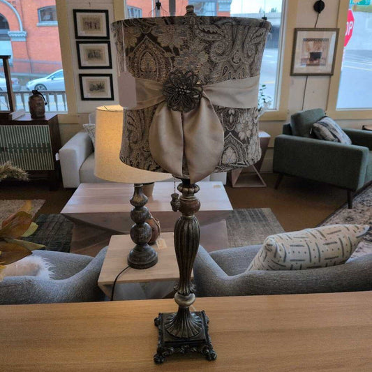 Decorative lamp with paisley shade on a wooden surface in a living room setting