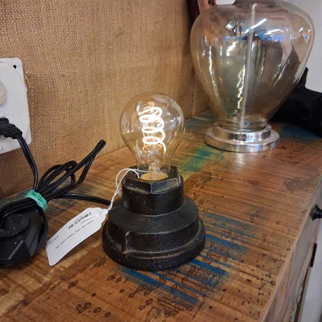 Vintage-style light bulb on a wooden surface with a plain background