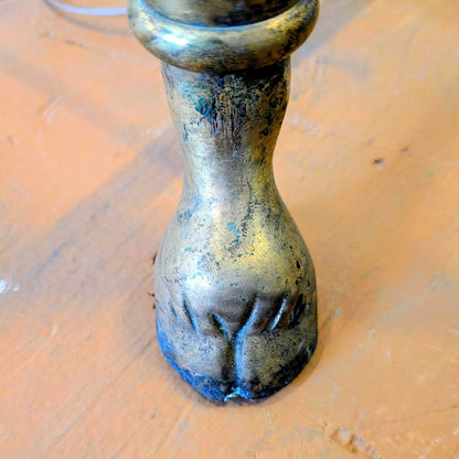Bronze candle holder with paw print design on a wooden surface