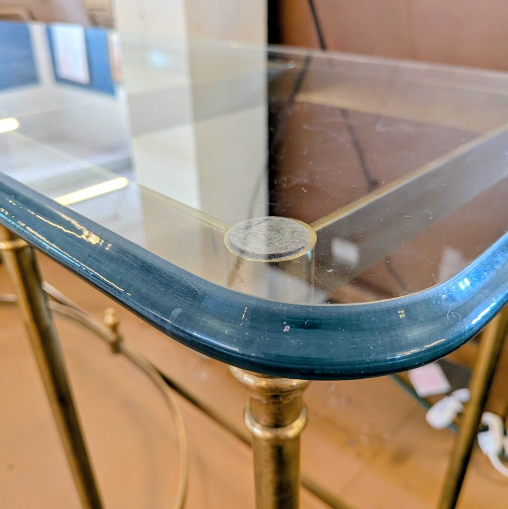 Glass table with gold metal legs in a store setting