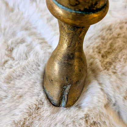 Close-up of a brass candle holder on a textured fur surface