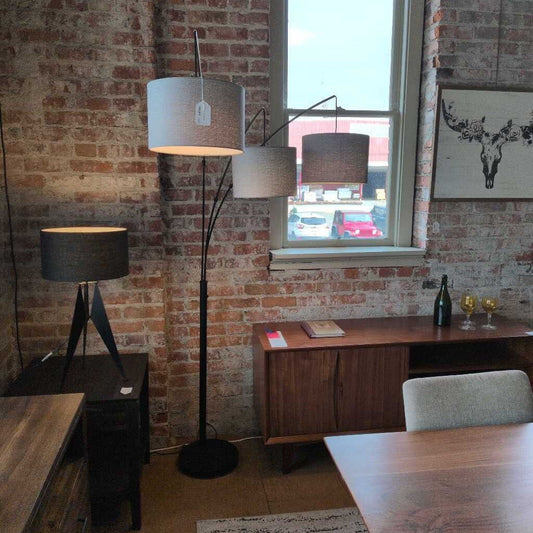 Room interior with brick wall, floor lamps, and a window view.