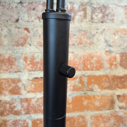 Black metal stand against a brick wall