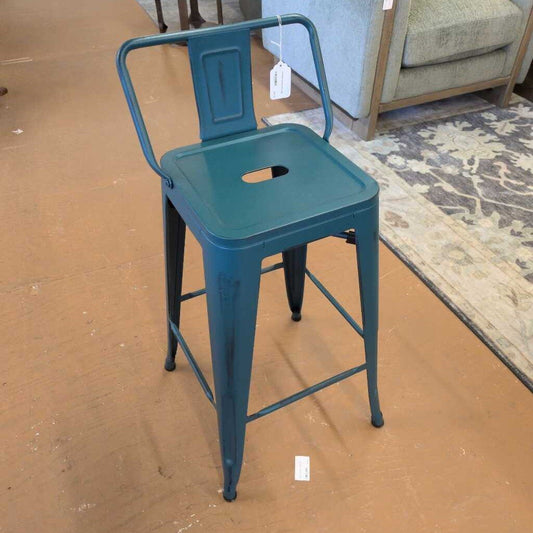 Blue metal bar stool with a backrest on a brown floor.