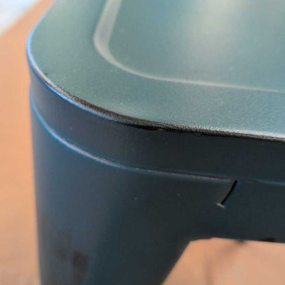 Close-up of a dark blue container with a lid on a wooden surface