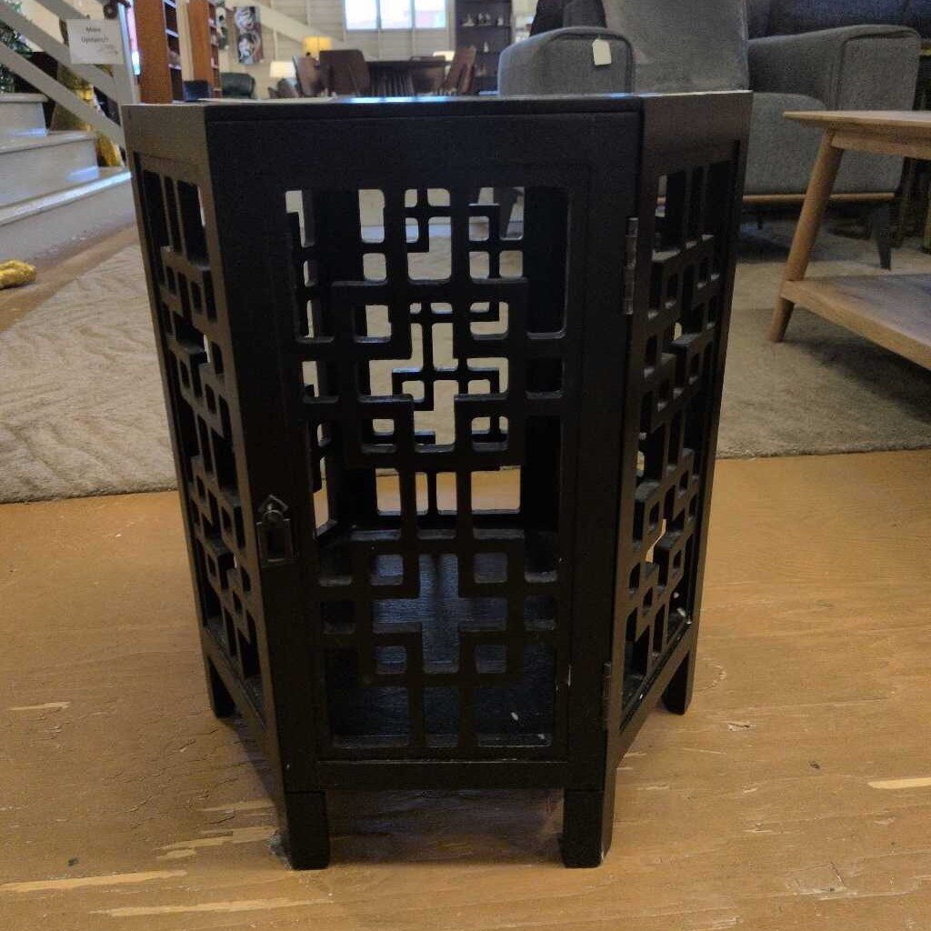Black lattice-patterned side table in a room setting