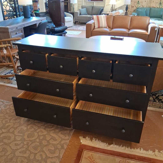 Dark wooden dresser with multiple drawers in a living room setting