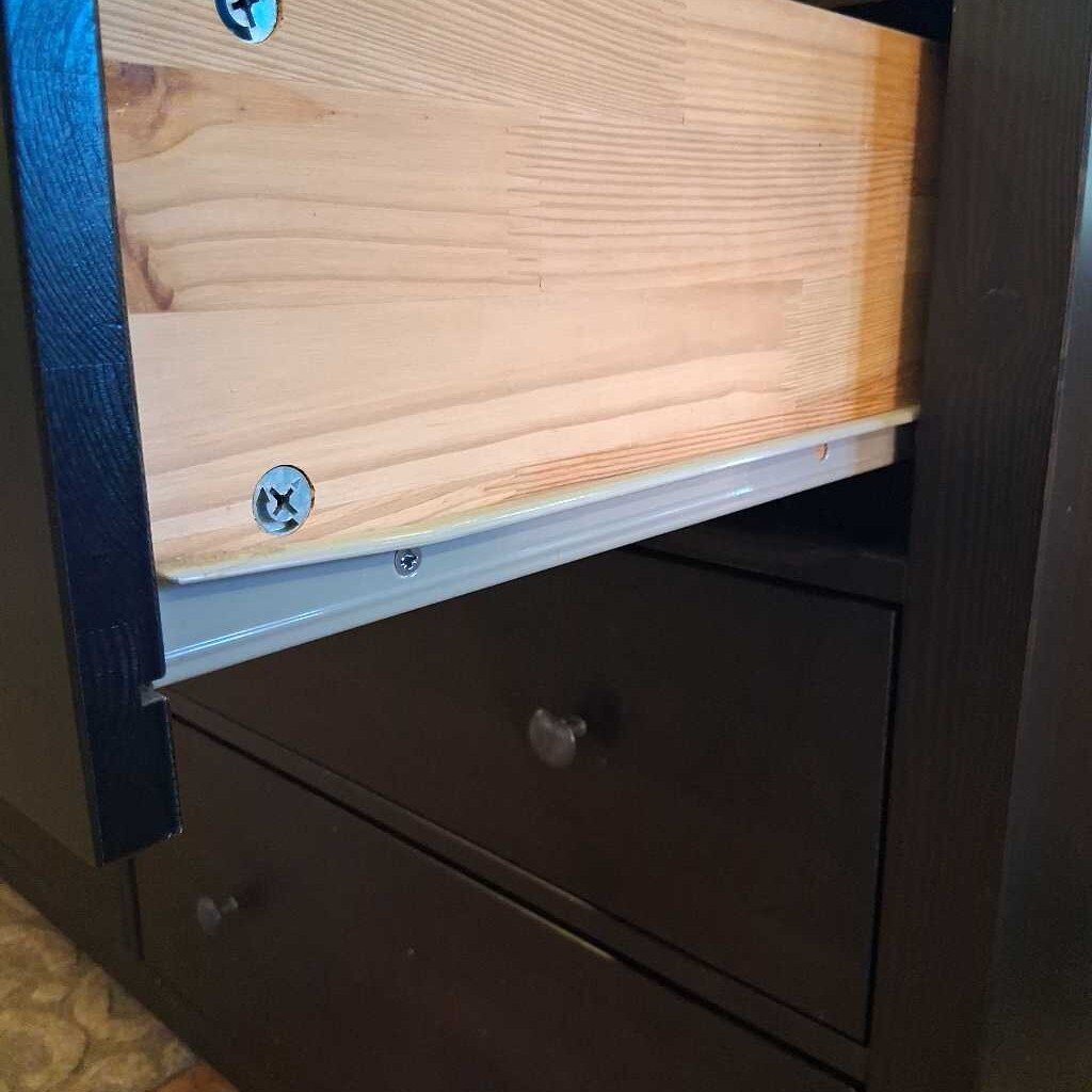 Wooden panel with screws attached to a dark surface