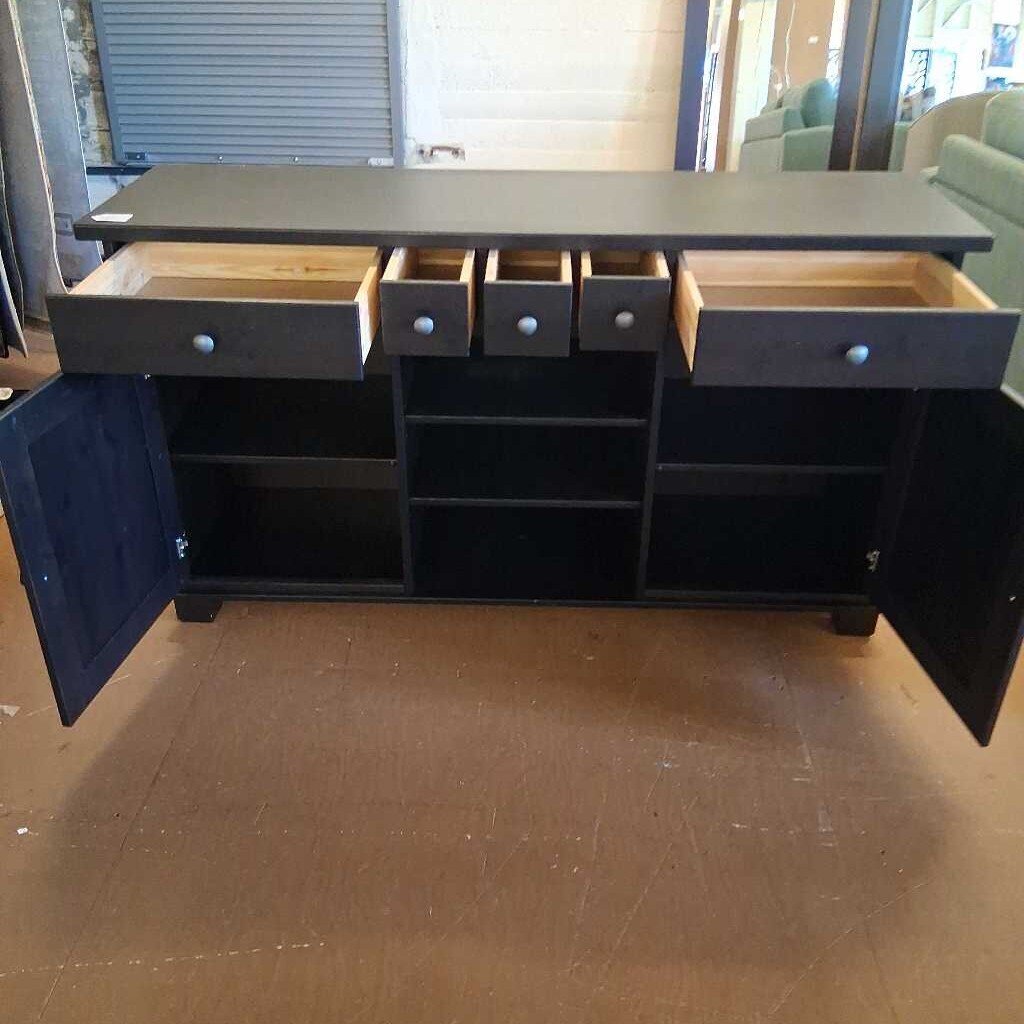 Dark gray sideboard with open doors and drawers on a wooden floor.