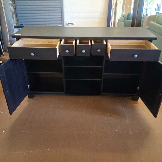 Dark gray sideboard with open doors and drawers on a wooden floor.