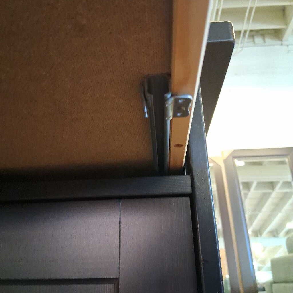 Close-up of a metal handle on a wooden door with a blurred background