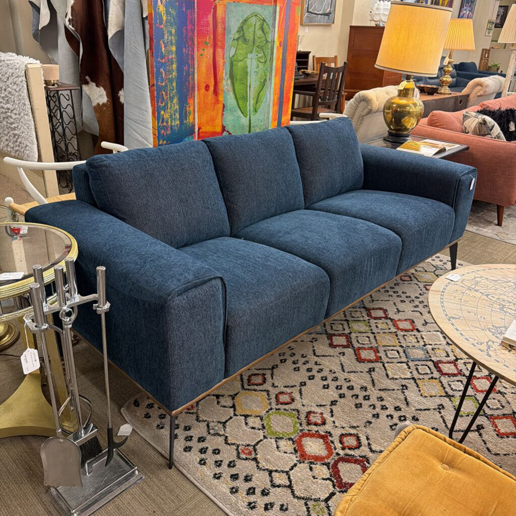 Blue sofa in a room with colorful rug and various decor items