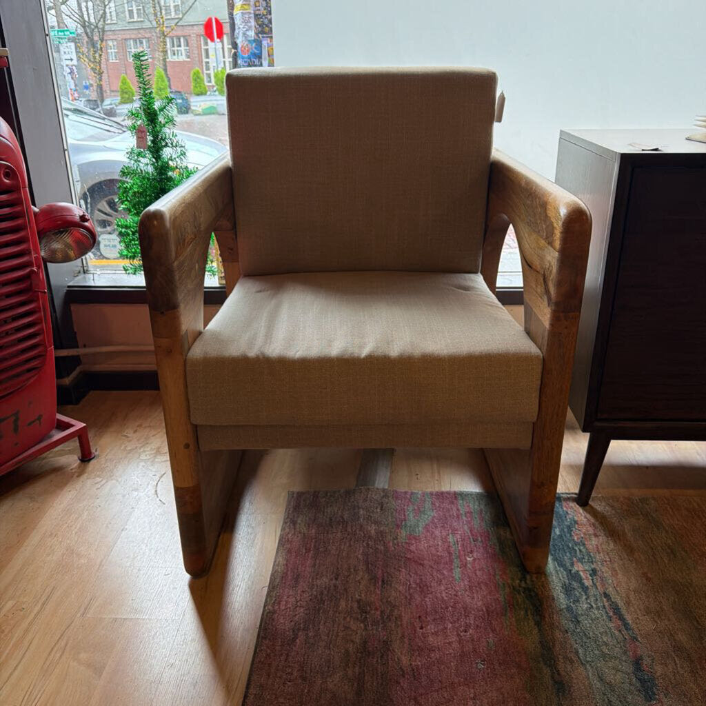 Beige armchair in a room with a window and colorful rug