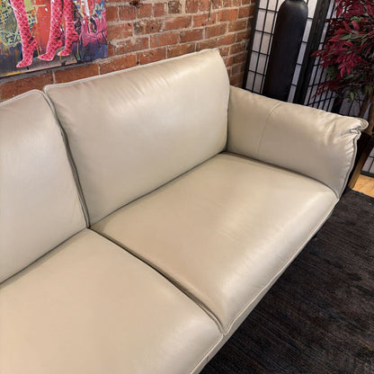 Beige sofa in a room with a brick wall and decorative elements.