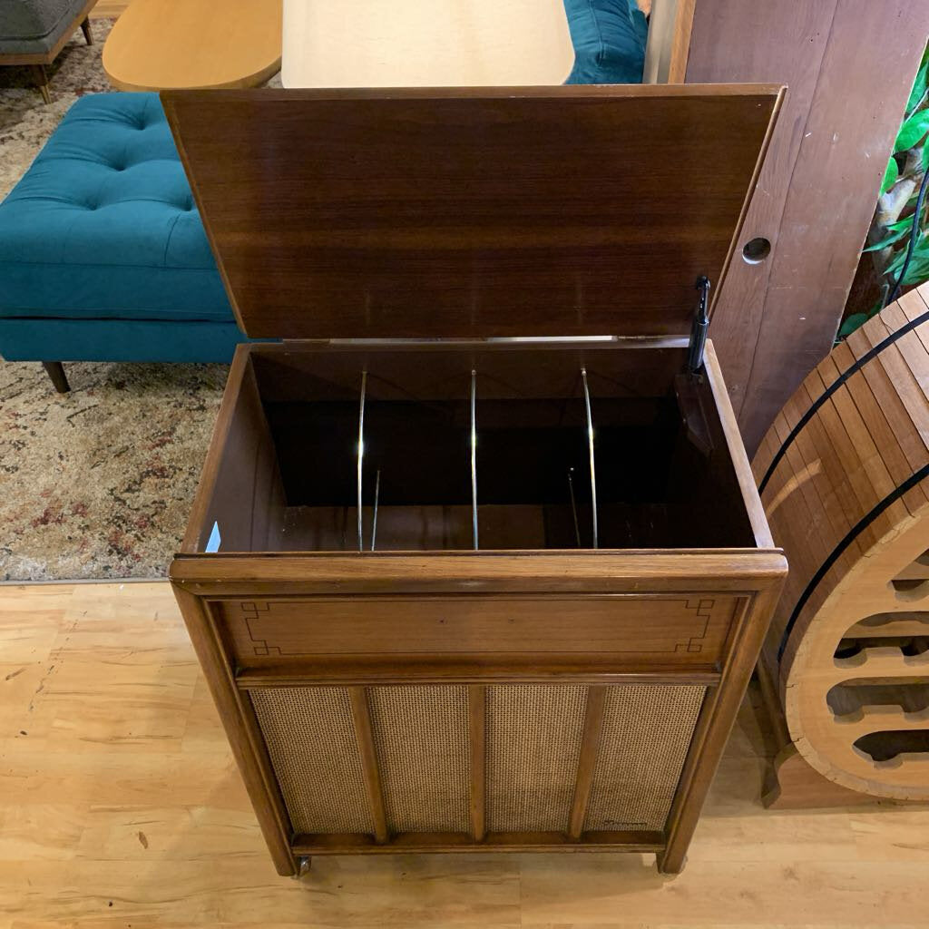 Wooden storage chest with open lid on a wooden floor.