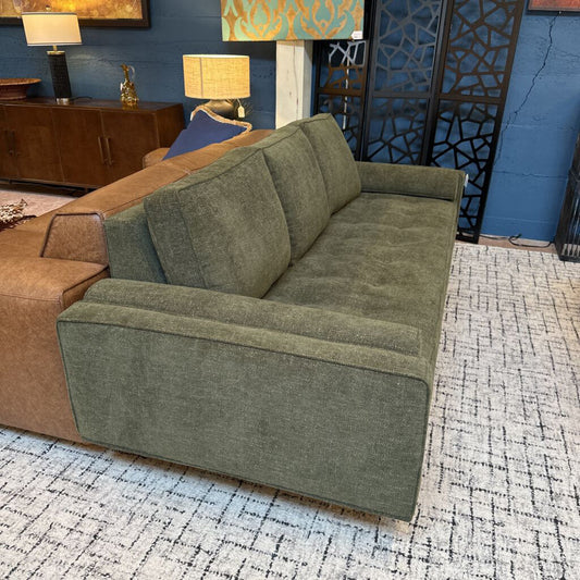 Green sofa in a room with decorative elements and furniture.