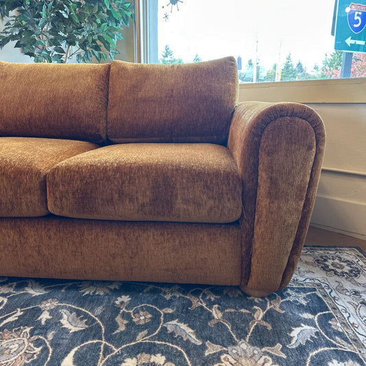 Brown sofa in a room with a window and plant