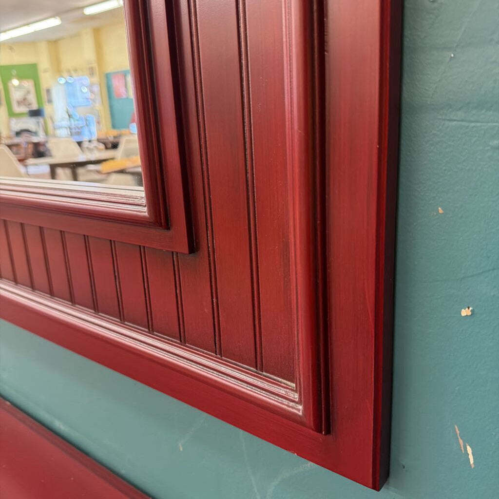 Close-up of a red wooden frame on a green wall