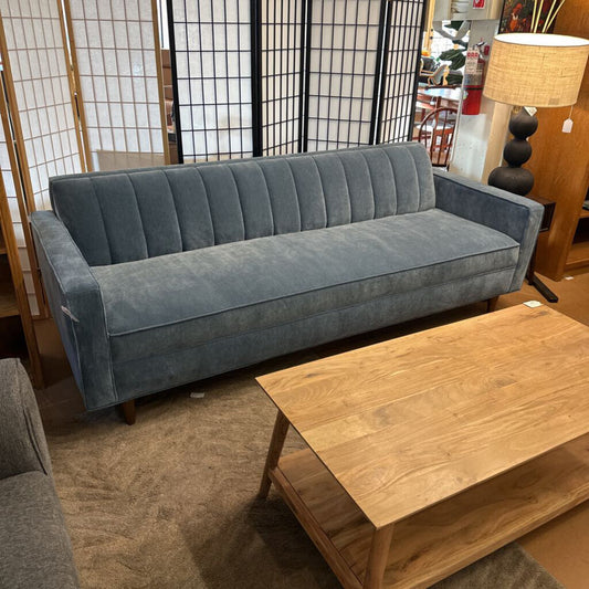 Gray sofa in a room with wooden coffee table and decorative items