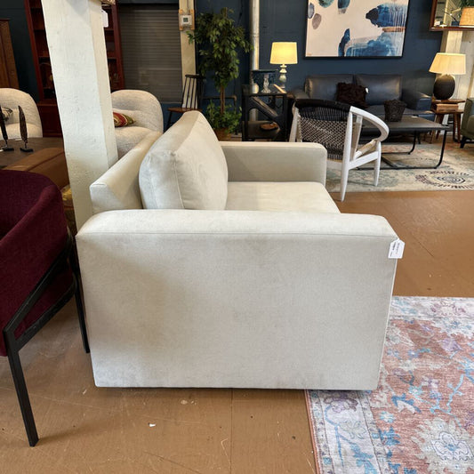 Beige armchair in a room with other furniture and decor