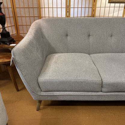 Gray sofa in a room with wooden flooring and a wooden screen in the background