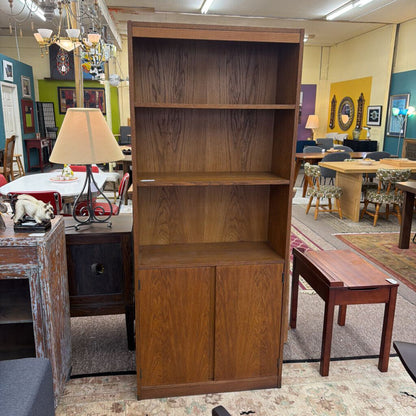 Wooden bookshelf in a room with tables and chairs