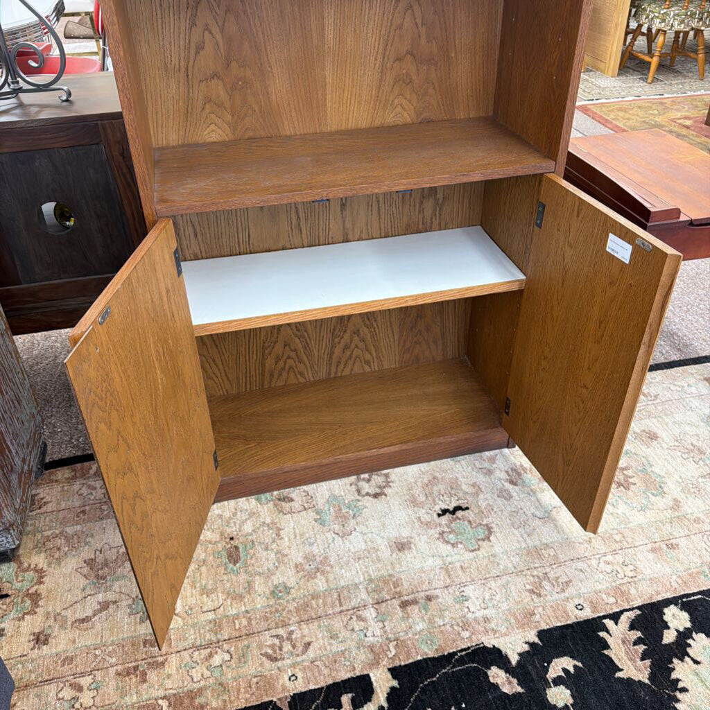 Wooden cabinet with open doors on a patterned rug