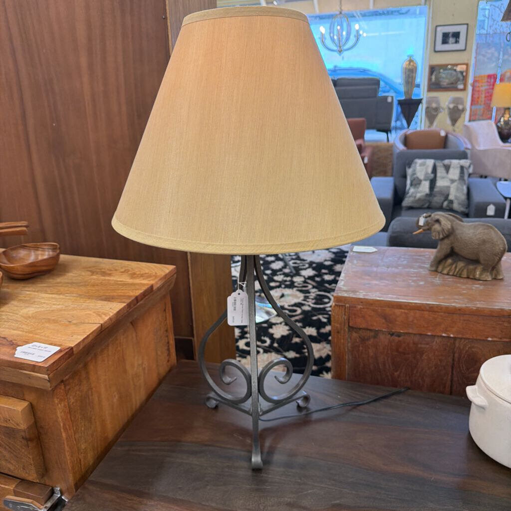 Table lamp with beige shade on a wooden surface in an indoor setting