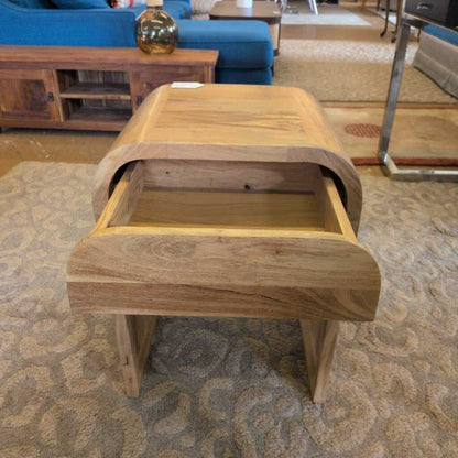 Wooden side table on a patterned carpet with a blurred background