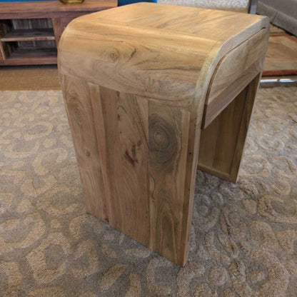 Wooden stool with a textured surface on a patterned carpet