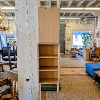 Tall wooden bookshelf in a room with furniture and decor