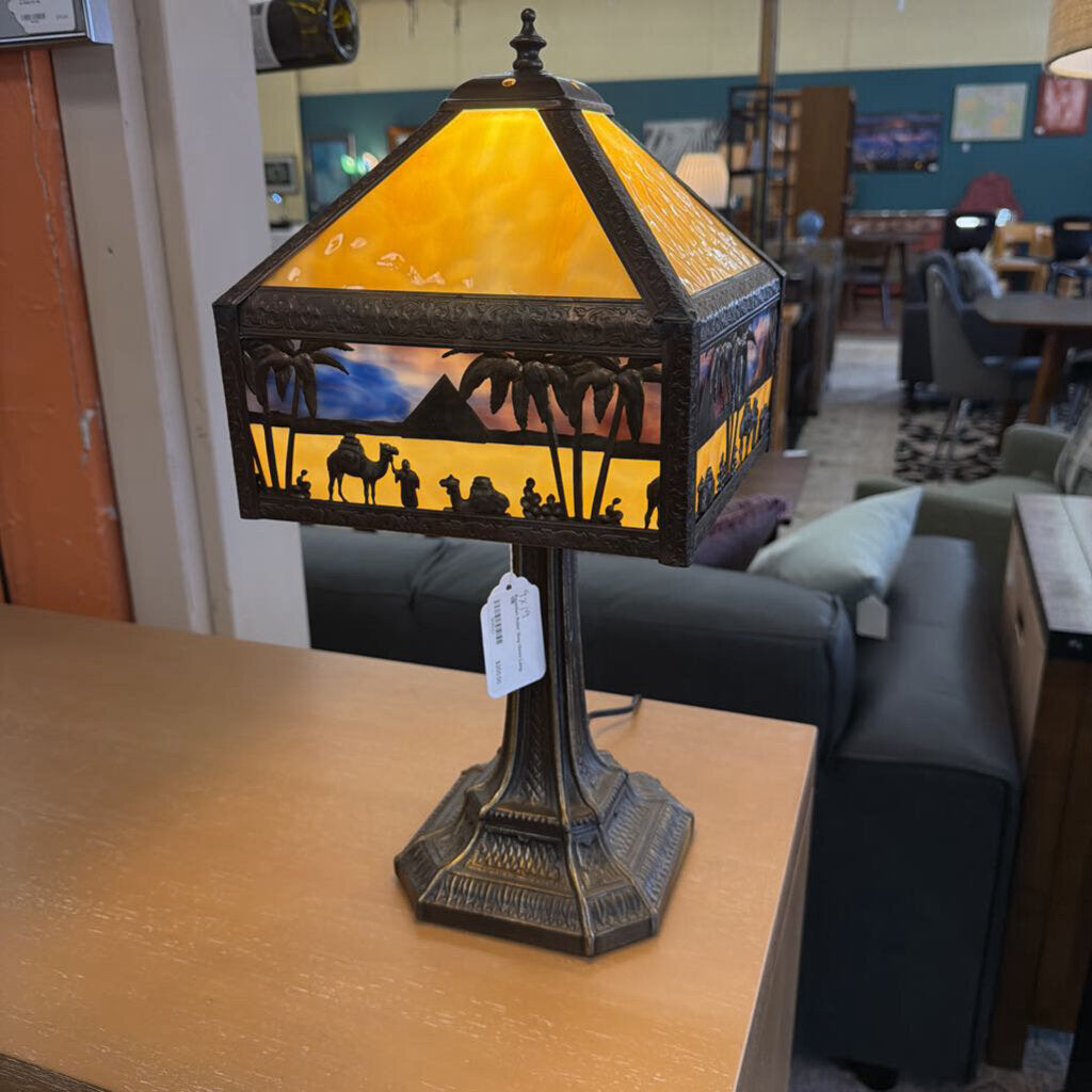 Decorative table lamp with stained glass design on a wooden surface.