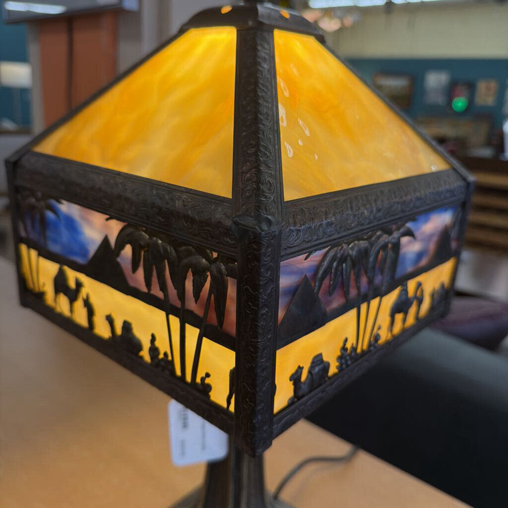 Decorative lamp with stained glass design featuring people and landscape.