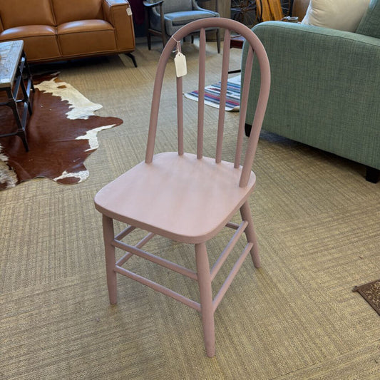 Pink chair with a tag on a carpeted floor in a room with furniture.