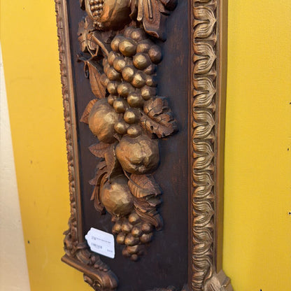 Decorative wall piece with gold grapes and leaves on a yellow background