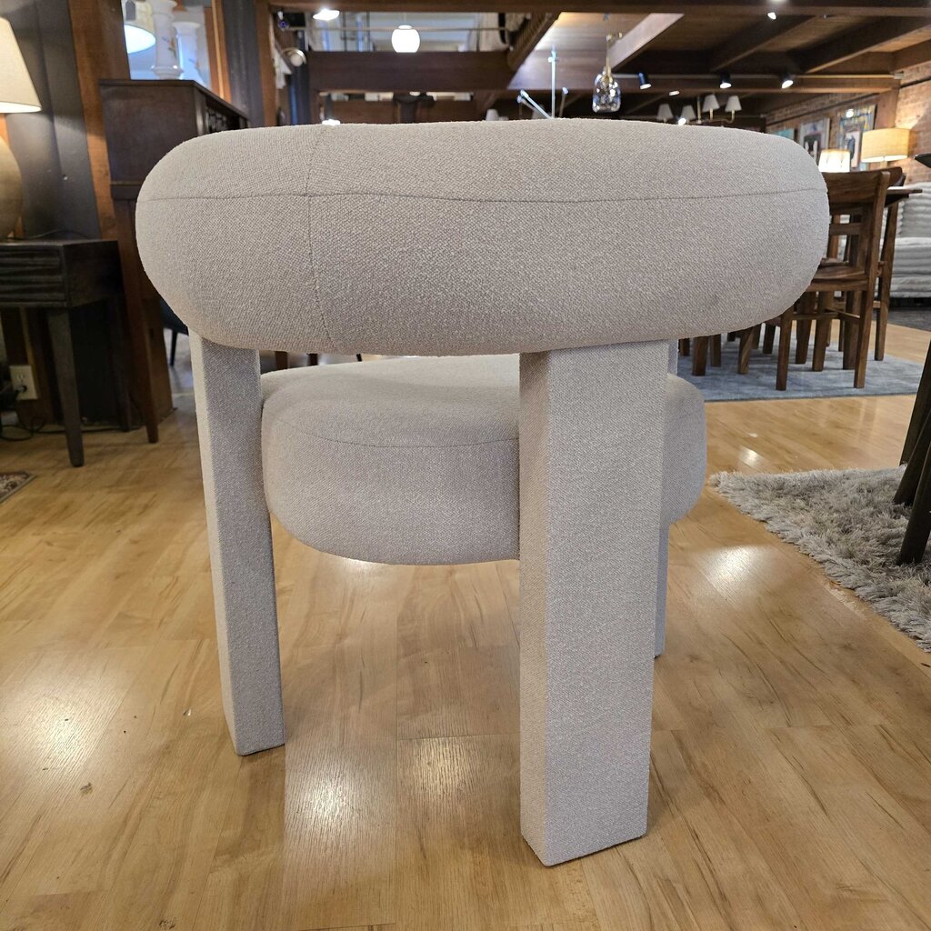 Modern chair with cylindrical seat and legs on a wooden floor