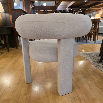 Modern chair with cylindrical seat and legs on a wooden floor