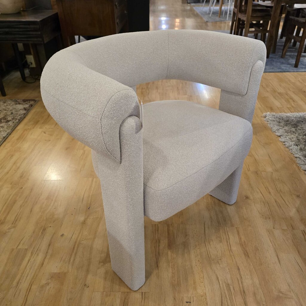 Gray armchair on a wooden floor with a blurred background