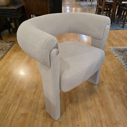 Gray armchair on a wooden floor with a blurred background