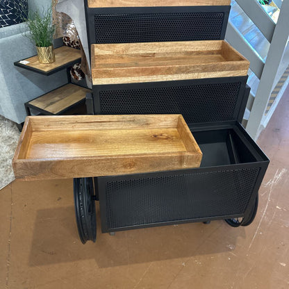 Wooden tray on a black metal cart with steps in the background