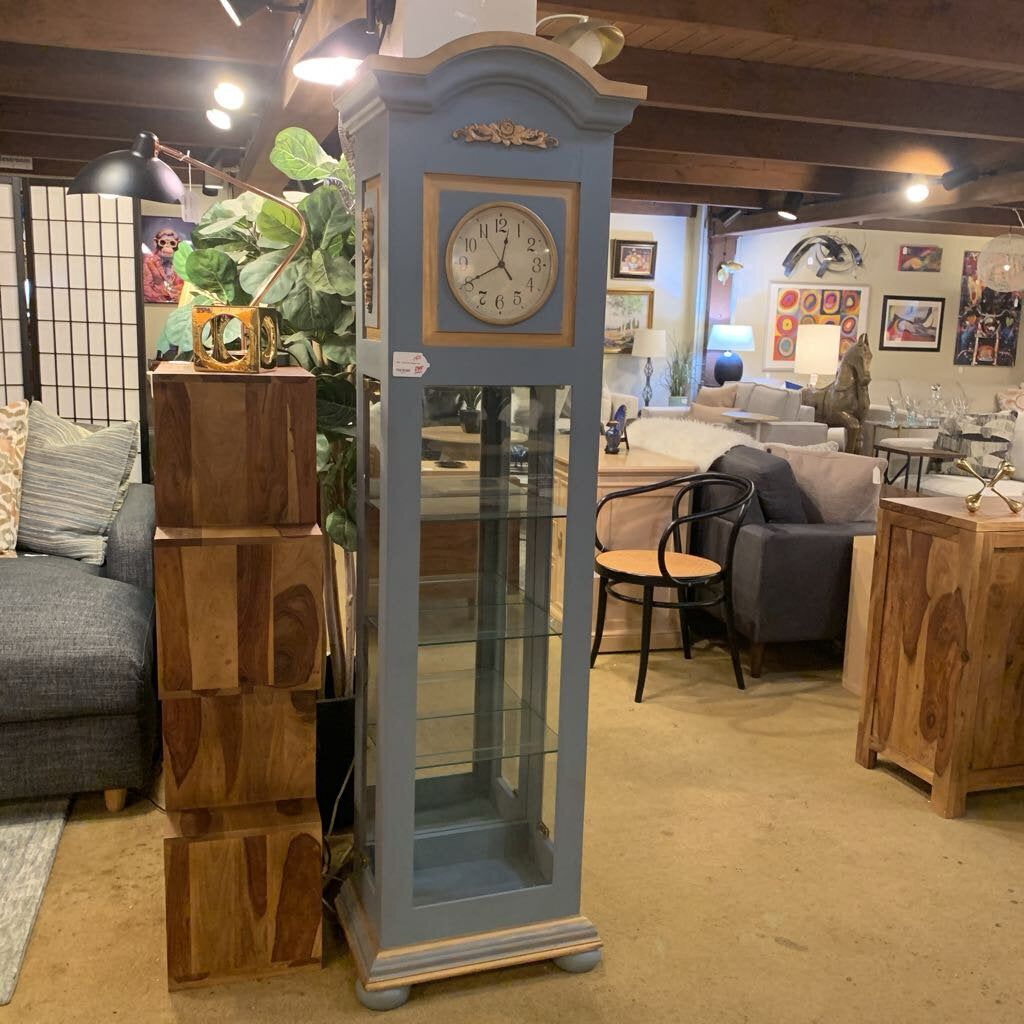 Blue grandfather clock in a room with furniture and decor
