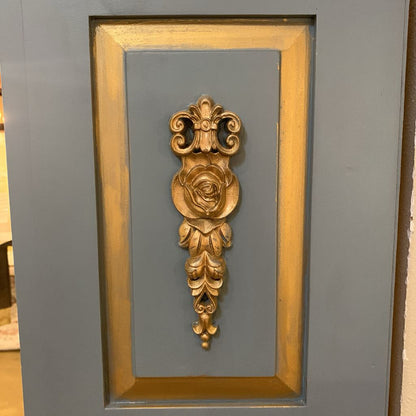 Decorative gold wall piece on a gray background