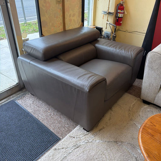 Gray leather sofa in a room with a door and fire extinguisher visible