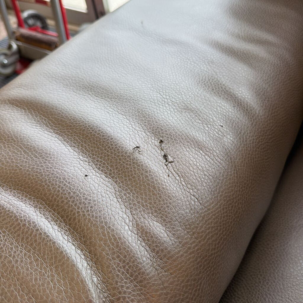 Beige leather surface with visible wear and tear