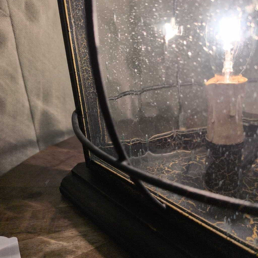 Vintage-style lamp with a light bulb inside a textured glass shade.
